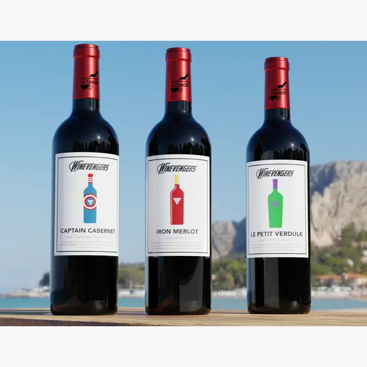 Bouteilles de vin rouge Compagnons du Canon Winevengers : Captain Cabret, Iron Merlot et Red Panther, étiquettes décalées et humour garanti.